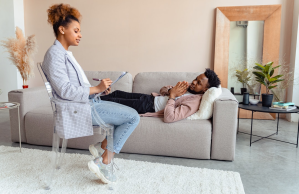 Man lying on couch talks to his therapist
