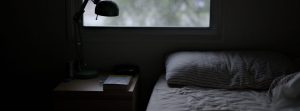 Slept in bed with a window, nightstand and a book.
