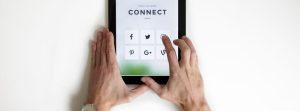 Hands holding & tapping a tablet.