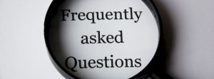 Words "Frequently asked Questions" inside a zoomed magnified glass.