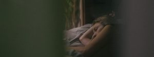 Woman depressed laying in bed.
