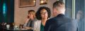 Woman speaking to a man in public restaurant.