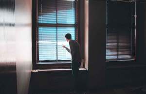 man looking out window.
