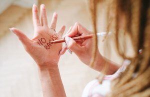 no racism written one woman's hand in marker