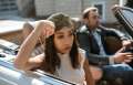 Sad woman in turban sits in passenger side of convertible car