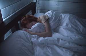 Woman sleeping in bed under the covers.