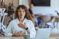Woman in a white shirt in an office practicing calming techniques
